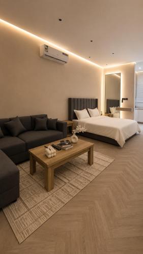 a living room with a bed and a coffee table at Luxury Smart Entry Studio in Buraydah