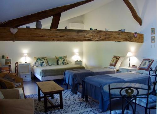 a bedroom with two beds with blue sheets at Métairie du Peyré in Pauilhac