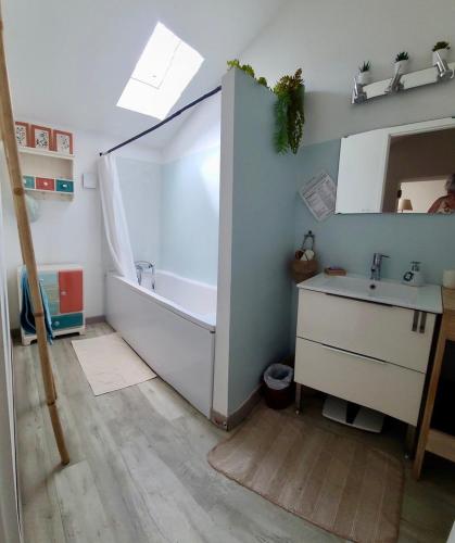 a bathroom with a bath tub and a sink at Métairie du Peyré in Pauilhac
