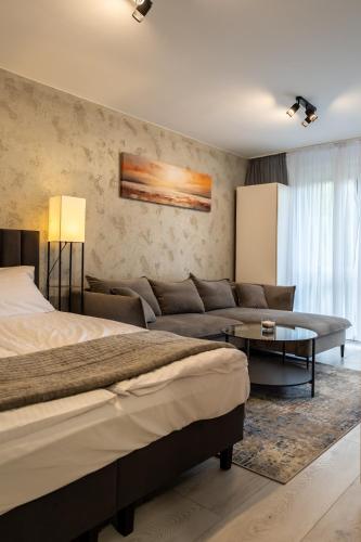 a bedroom with a bed and a couch and a table at Apartament Targowa 9A41 in Uniejow