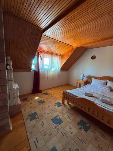 a bedroom with a bed and a wooden ceiling at Casa cu şemineu in Păuşa