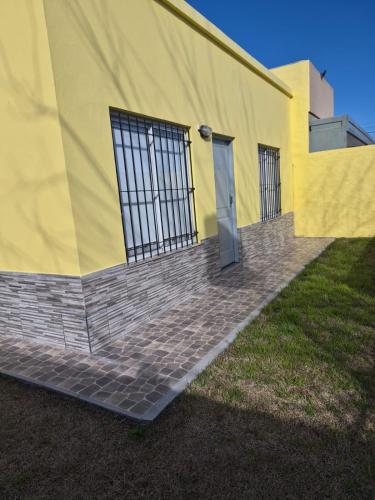 a yellow building with a door on the side of it at Casa Amarilla in Luján