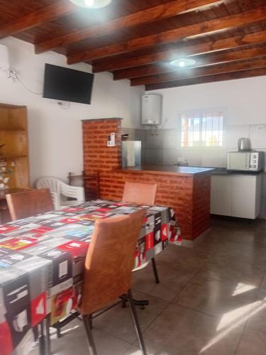 a room with a table and chairs and a kitchen at Casa Amarilla in Luján