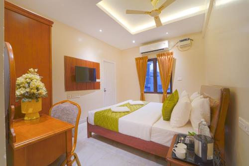 a bedroom with a bed and a table and a television at YAFA Palace in Rāmanāthapuram