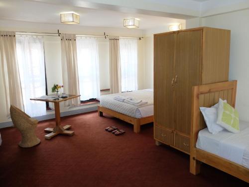 a bedroom with a bed and a table and a bed and a desk at Lalit Heritage Home in Pātan