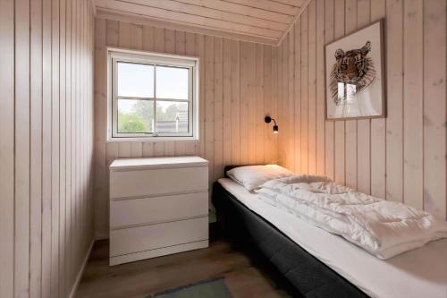 a small bedroom with a bed and a window at 16666-Farevejle-Karuphoj-4-E in Fårevejle