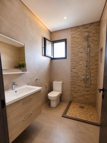 a bathroom with a sink and a toilet and a window at Villa ines in Taguermess