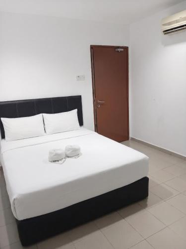 a bed with two white towels on top of it at Swing & Pillows - Kuala Selangor in Kuala Selangor
