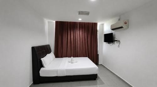 a bedroom with a white bed and a red curtain at Swing & Pillows - Kuala Selangor in Kuala Selangor