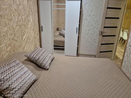 a bedroom with a bed with two pillows and a mirror at Modern Apartment Near Sevan Lake in Sevan
