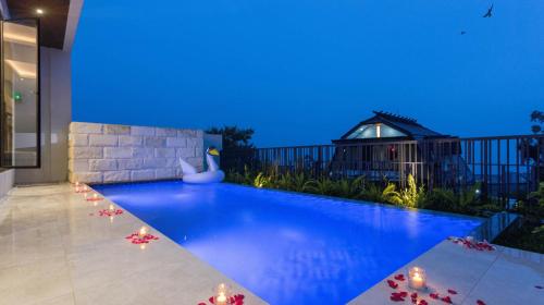 a swimming pool in a house with a blue light at Alcola Boutique Villa - Astonia Unit in Batu
