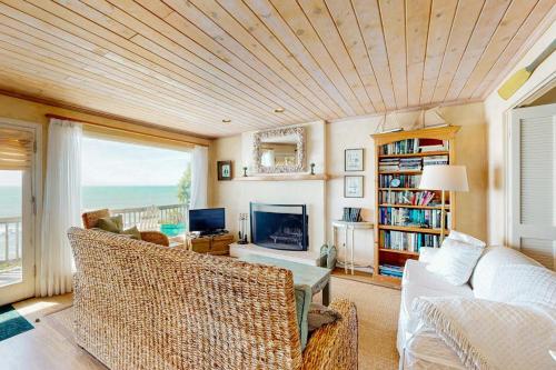 a living room with a couch and a tv at Oceanfront Delight in Cayucos