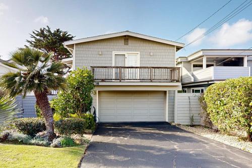 a house with a garage and a palm tree at Oceanfront Dream in Cayucos