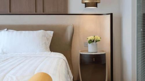 a bedroom with a bed and a vase of flowers on a table at Alcola Boutique Villa - Bahama Unit in Malang