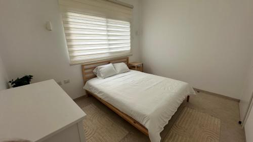 a small bedroom with a bed and a window at Private Pool Retreat for Two - Golan in Qasrîne