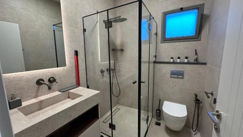 a bathroom with a shower and a toilet and a sink at Private Pool Retreat for Two - Golan in Qasrîne
