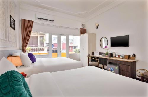 a hotel room with two beds and a television at The Lake Silk Hotel & Travel in Hanoi