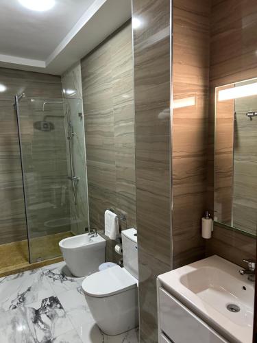 a bathroom with a toilet and a sink and a shower at Appart Hôtel Stade Tanger in Tangier