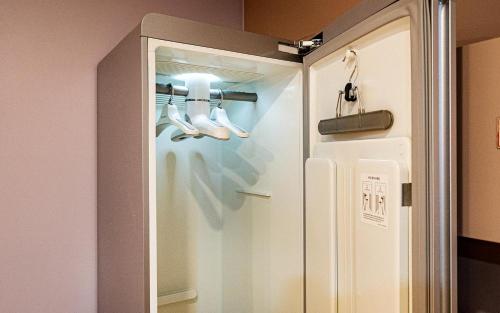a glass door with shoes in it next to a refrigerator at Bupyeong Byulha Hotel in Incheon