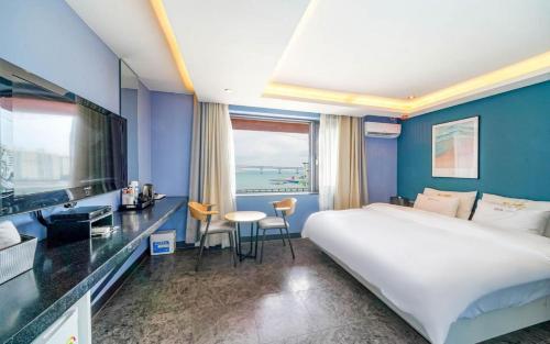 a hotel room with a large bed and a television at Busan Gwangalli SEAYOU HOTEL in Busan