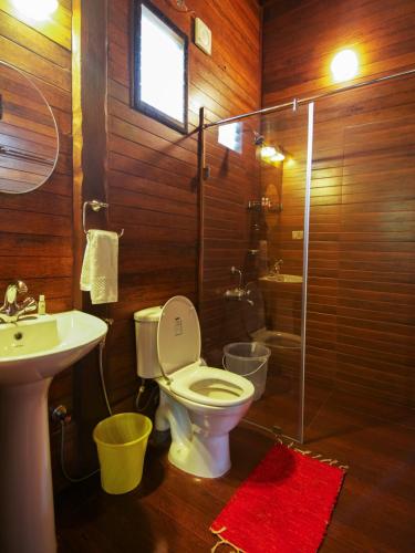 a bathroom with a toilet and a sink and a shower at Stanmore Garden Bungalow in Vālpārai