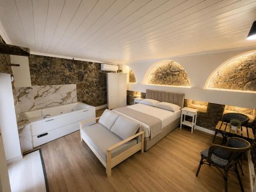 a bedroom with a bed and a sink and a tub at Aprosmeno House 5 in Agros