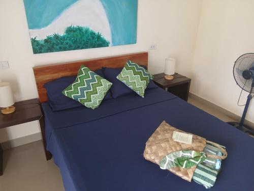a bed with blue sheets and pillows in a room at HIGALA Resort in Panglao Island