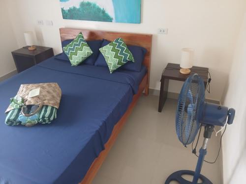 a bedroom with a blue bed and a fan at HIGALA Resort in Panglao Island