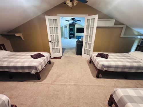 two beds in a room with two open doors at Hale Halai in Hauula