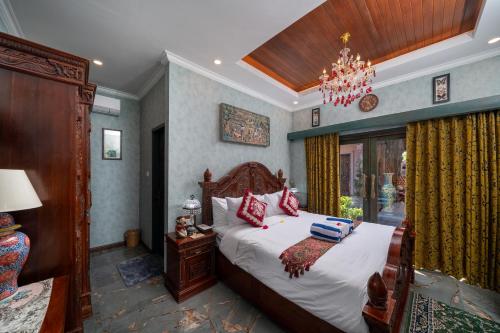 a bedroom with a bed and a chandelier at Puri Mayapada Nusa Dua Bali in Nusa Dua