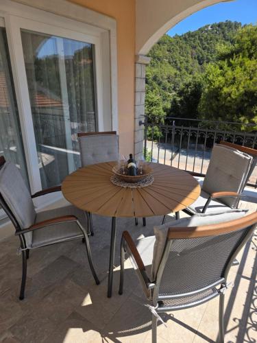 a wooden table and chairs on a patio at Nano Apartmani in Smokvica
