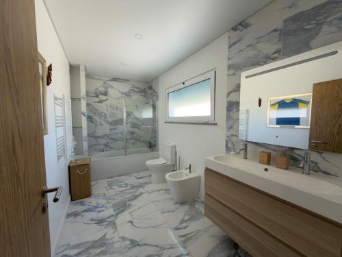 a bathroom with a toilet and a sink at Vila Grafenola in Montargil