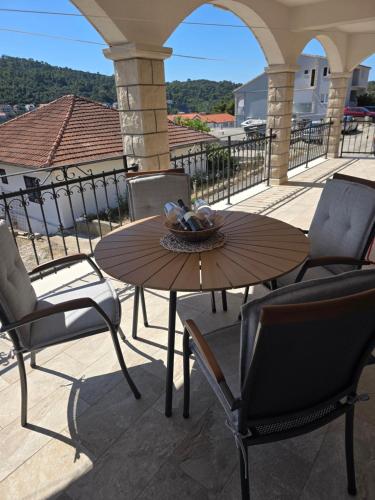 a wooden table and chairs on a patio at Nano Apartmani in Smokvica