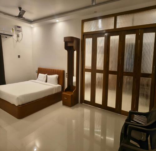 a bedroom with a bed and a window and a chair at Greenway Retreat Resort in Puducherry Airpoert