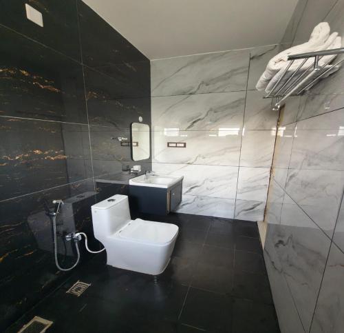 a bathroom with a white toilet and a sink at Greenway Retreat Resort in Puducherry Airpoert