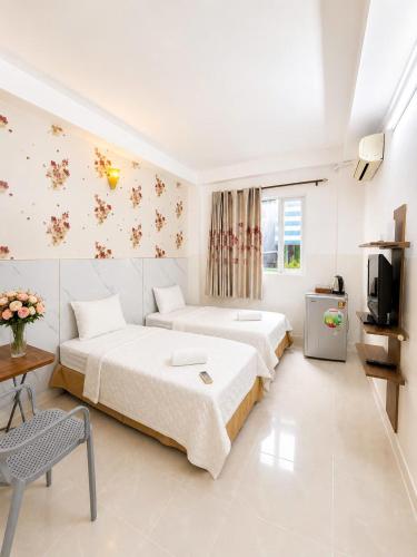 a hotel room with two beds and a television at Thanh Ha Guesthouse in Ho Chi Minh City