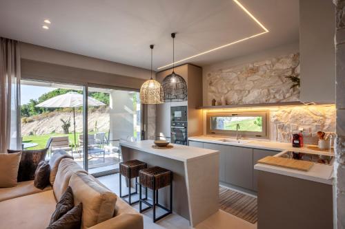 a kitchen and living room with a couch and a table at Kallies villas with shared Pool in Pefkochori