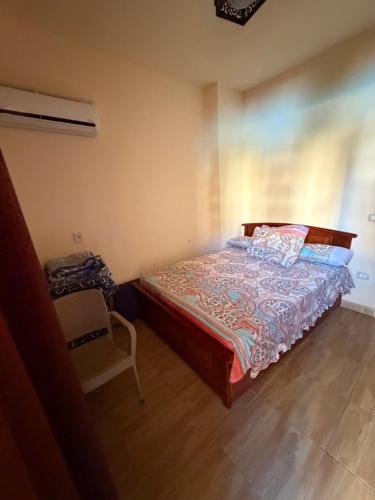 a bedroom with a bed and a chair in it at Oraby house in Al Ḩammām