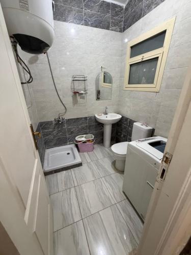 a bathroom with a toilet and a sink at Oraby house in Al Ḩammām