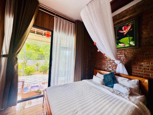 a bedroom with a bed and a large window at Son House in Dong Hoi