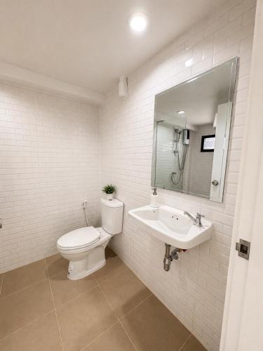 a bathroom with a toilet and a sink and a mirror at Vanda Resort & Villa in Ban Thai Don (1)