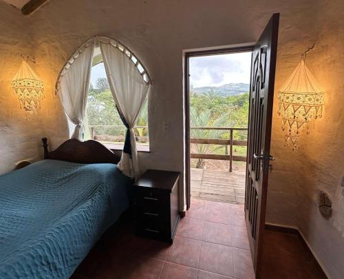 a bedroom with a bed and a large window at Hotel el Amanecer in Samaipata