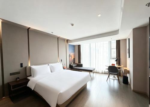 a large white bed in a hotel room at Atour Hotel Kunming Hi-tech Wuyue Plaza in Kunming