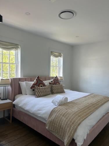 a large bed in a bedroom with white walls and windows at The Berrima Vault House in Berrima