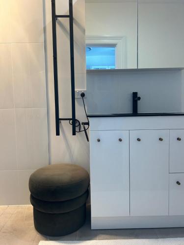 a bathroom with a stool and a sink and a mirror at The Berrima Vault House in Berrima