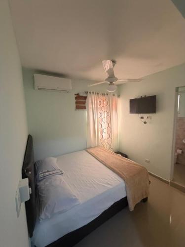 a bedroom with a bed and a ceiling fan at Hostal mar de luna in Pedernales