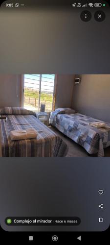 a bedroom with two beds and a window at Complejo El Mirador in Calingasta