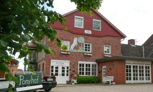 a red brick building with a sign on it at Ponyhof Naeve am Wittensee in Groß Wittensee