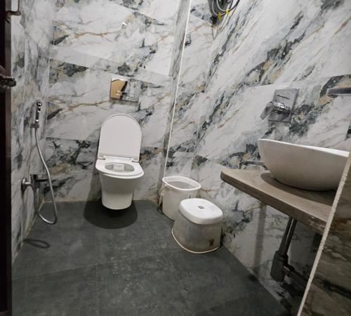 a bathroom with a toilet and a sink at New Skyrooms in Varanasi