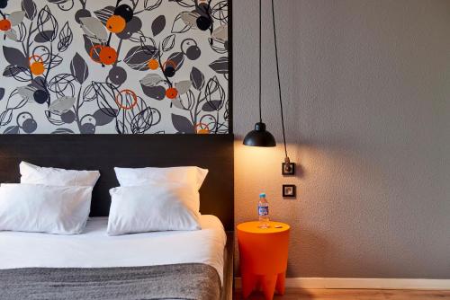 a bedroom with a bed and a bottle of water on a table at L'aparthoteL LhL in Dijon